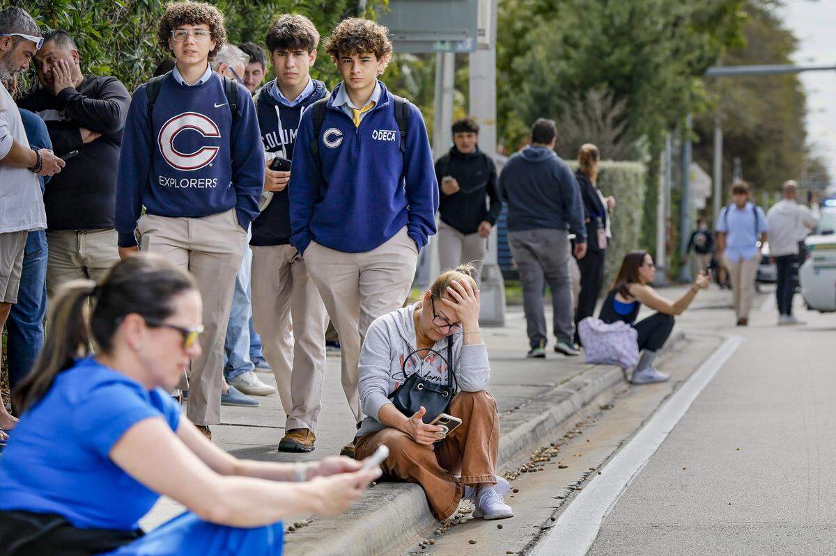 Parents wait on the curb along Southwest 87th Avenue after students are released from school. Miami-Dade Sheriff’s Office deputies responded to a threat made to Christopher Columbus High School on Wednesday, Feb. 4, 2026, in Miami. Authorities said the call was a false alarm that prompted a lockdown at the school, and officials reported that everyone was safe.