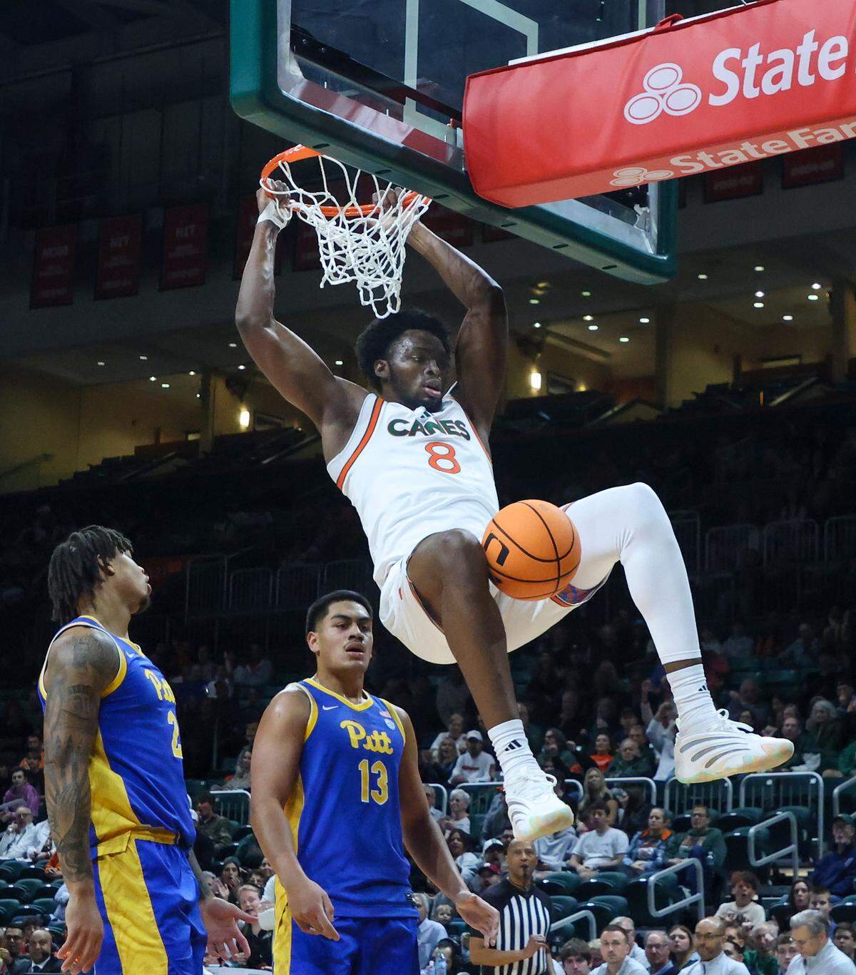 UM center Ernest Udeh, Jr., right, gets the dunk over Pitt players Cameron Corhen, left, and Roman Siulepa, center, in the first half as University of Miami (11-2) Men's basketball played against Pittsburgh (7-6) in the ACC opener at the Watsco Center in Coral Gables, Florida, on Sunday, December 14, 2025.