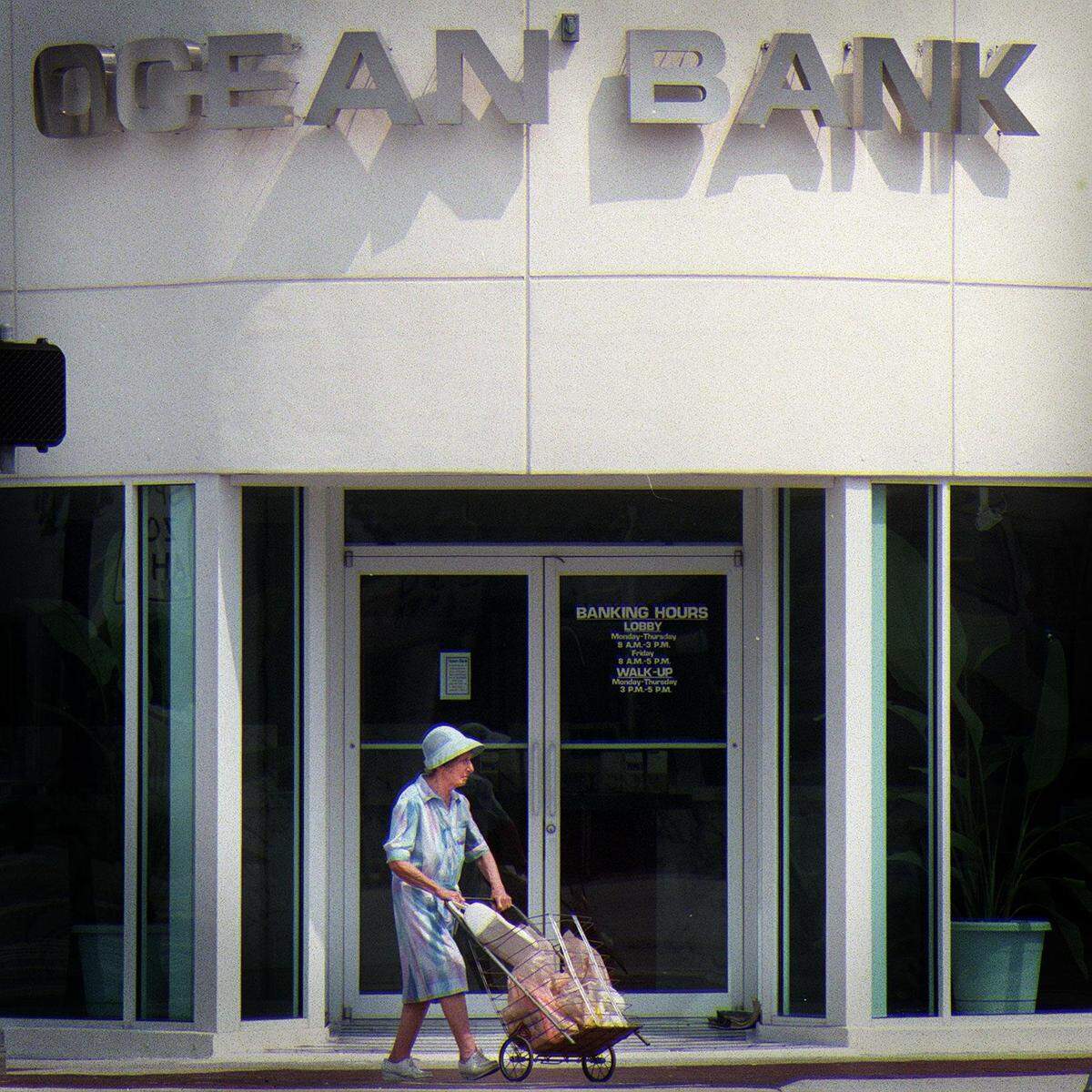 In the 1990s, more than a dozen banks dotted 41st Street in Miami Beach. In 1997, a woman walks by the entrance of the newly opened Ocean Bank.