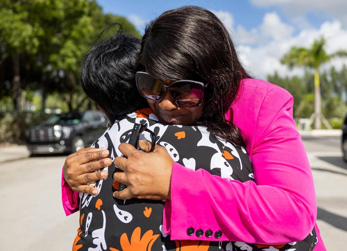 Marcia Dixon, mother of Edwin Dixon, and Robin Gore, mother of Taborez White, whose sons were killed in separate shootings at Cedar Grove Apartments, hug after speaking at a press conference outside the neighborhood on Wednesday, Oct. 23, 2024, in Miami Gardens, Fla. The event announced a lawsuit filed against the apartment’s property management following three shootings at the complex that left two dead and one injured.