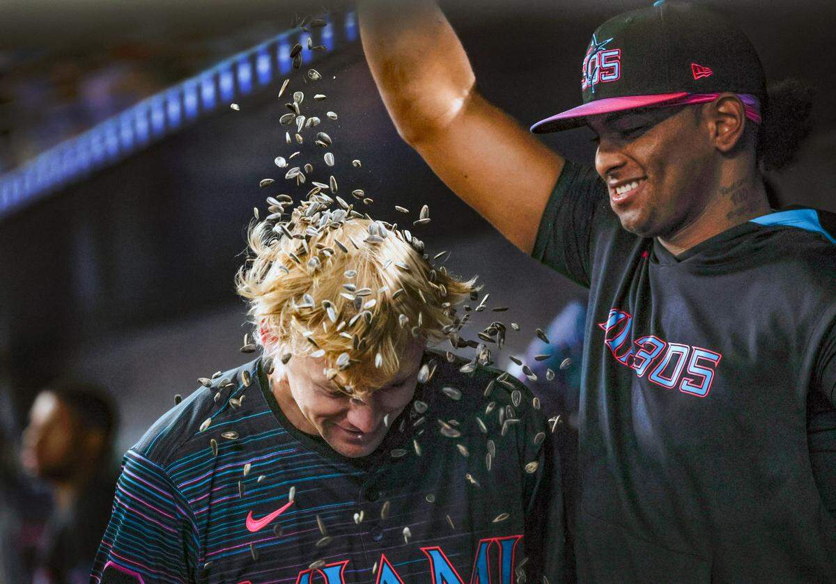 Miami Marlins outfielder Kyle Stowers (28) gets showered with sunflower seeds by pitcher Edward Cabrera (27) in the dugout after he homers on a fly to right field in the second inning against the Milwaukee Brewers at loanDepot park Miami, Florida on Saturday, July 5, 2025.