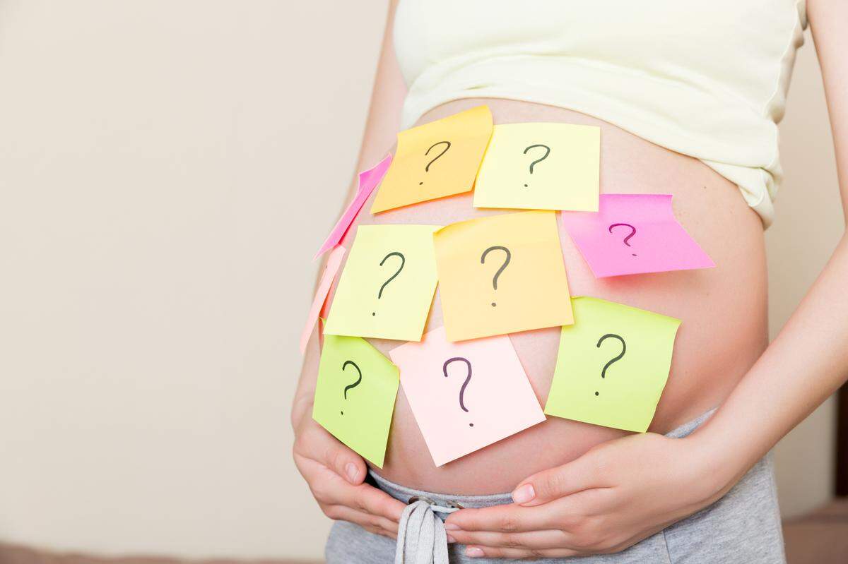 pregnant woman with question marks on belly