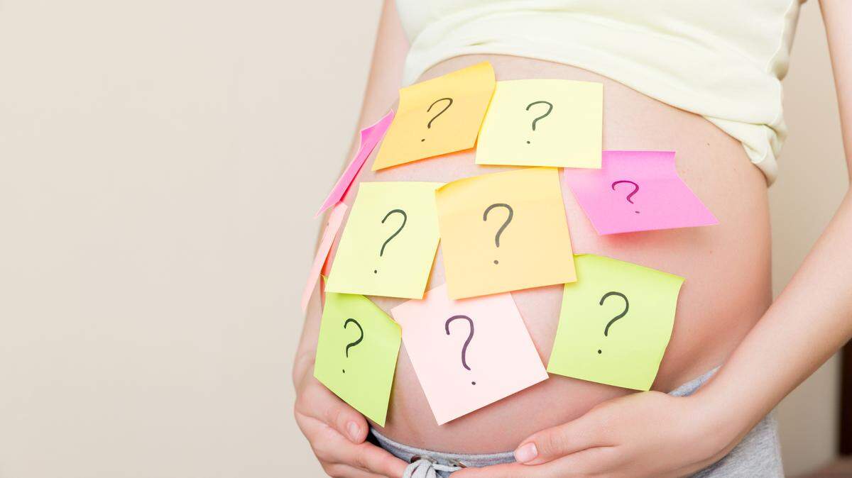 pregnant woman with question marks on belly