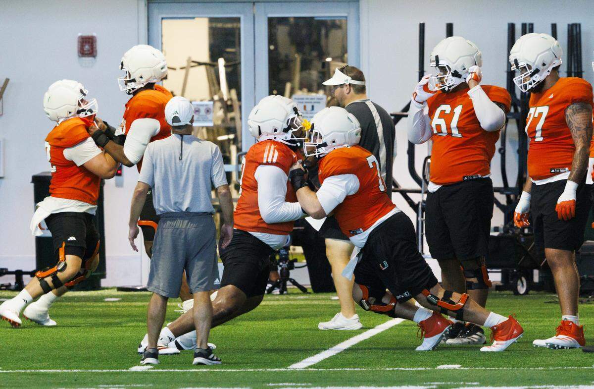 Offensive linemen Anez Cooper (73) and Ryan Rodriguez (76), center, run a drill during Miami Hurricanes football practice on Monday, Aug. 4, 2025, at University of Miami in Coral Gables, Fla.