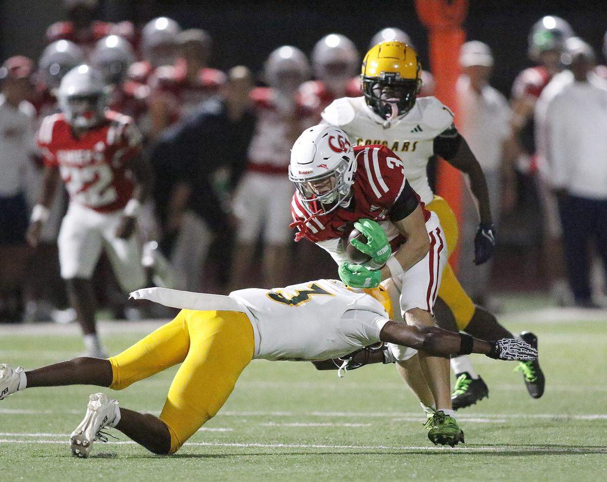Killian Cougars Quintero Frierson (3) tackles Cardinal Gibbons Chiefs wide receiver Merrick Todich (3) during Region 4-2A semifinal football game on Friday, November 21, 2025 at Cardinal Gibbons HS in Fort Lauderdale. Andrew Uloza / for Miami Herald