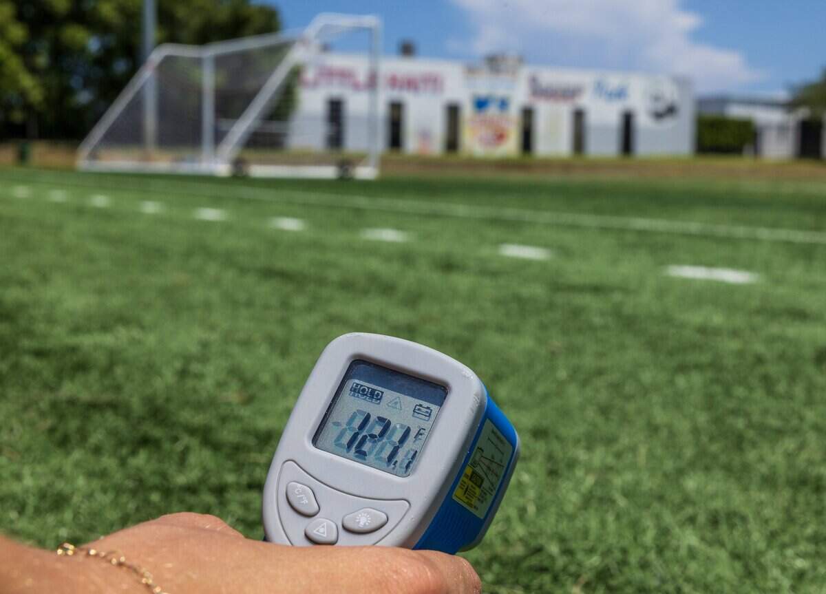 Miami Herald reporter Ashley Miznazi measures the temperature at the Little Haiti Soccer Park, that is covered with artificial turf at noon where temperatures measured up to (121) several degrees higher than in the natural turf covered areas, on Tuesday, July 29, 2025.