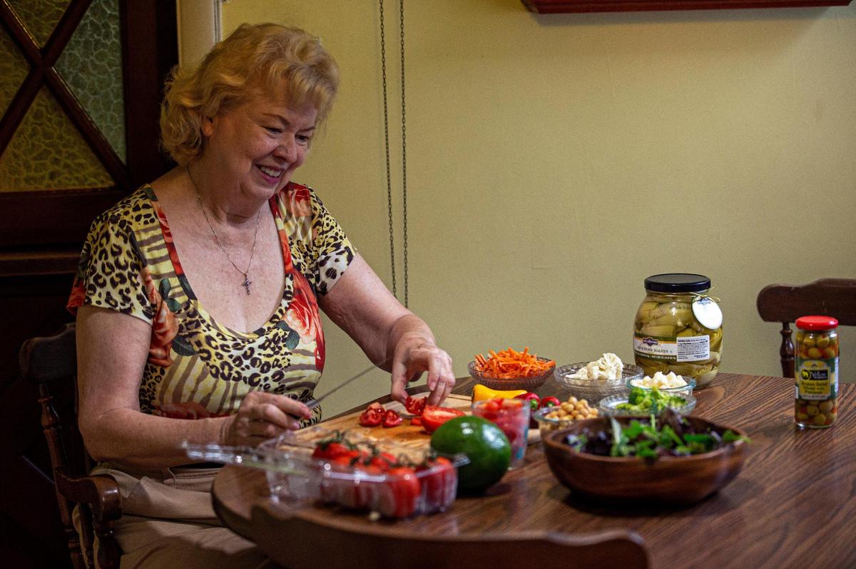 Susan Neuman, a Miami public relations professional who has diabetes, has adopted a more plant-based diet, which she credits to helping her get off insulin. She cuts up veggies in her home kitchen in Miami.