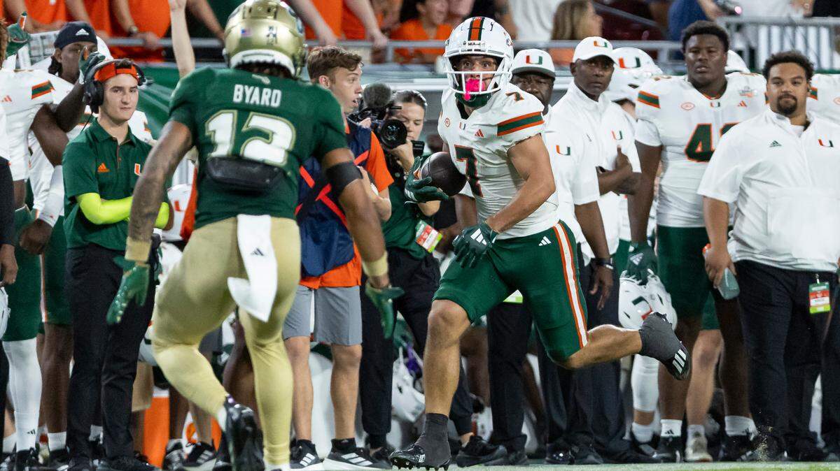 Miami Hurricanes wide receiver Xavier Restrepo (7) runs with the ball as South Florida Bulls safety Tawfiq Byard (12) defends in the second half of their NCAA college football game at the Raymond James Stadium on Saturday, Sept. 21, 2024, in Tampa, Fla.