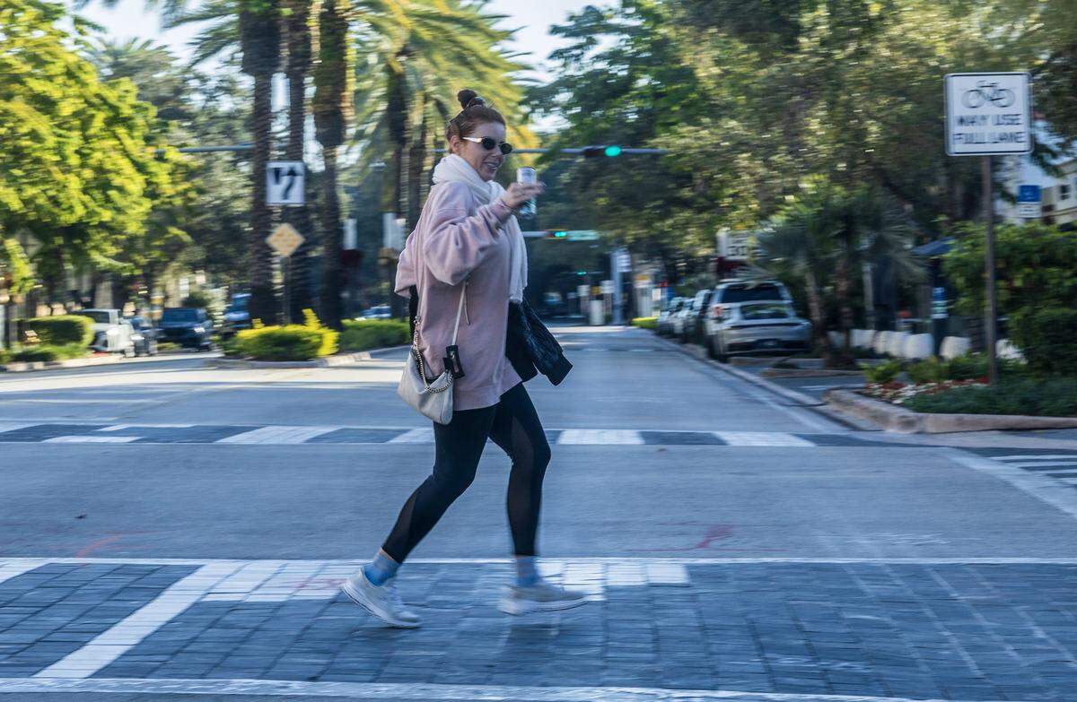 A woman crosses Miracle Mile, in Coral Gables as Miami woke to one of its coldest New Year's Eves in decades, on Wednesday, December 31, 2025. 