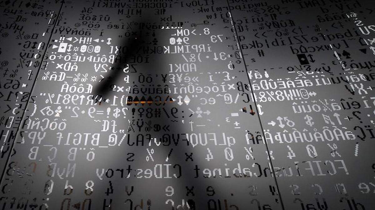 An employee walks behind a glass wall with machine coding symbols at the headquarters of Internet security giant Kaspersky in Moscow in 2016.