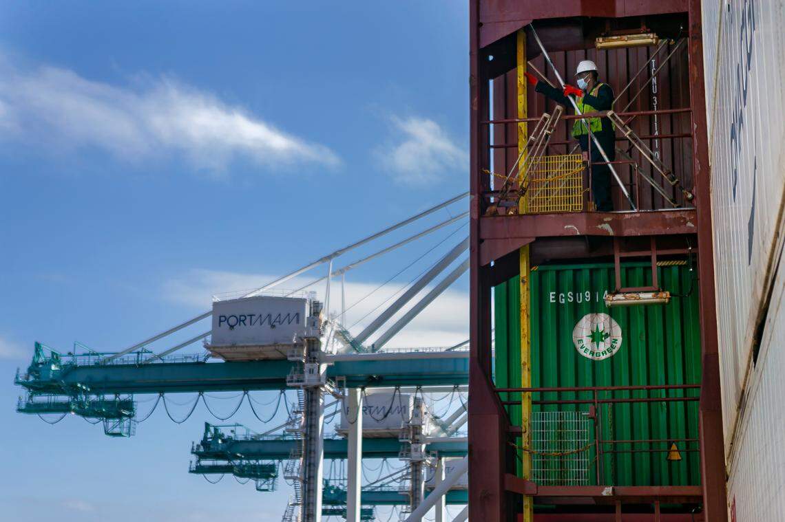 A longshoreman works to unhook containers inside a docked cargo ship at PortMiami on Saturday, February 20, 2021.