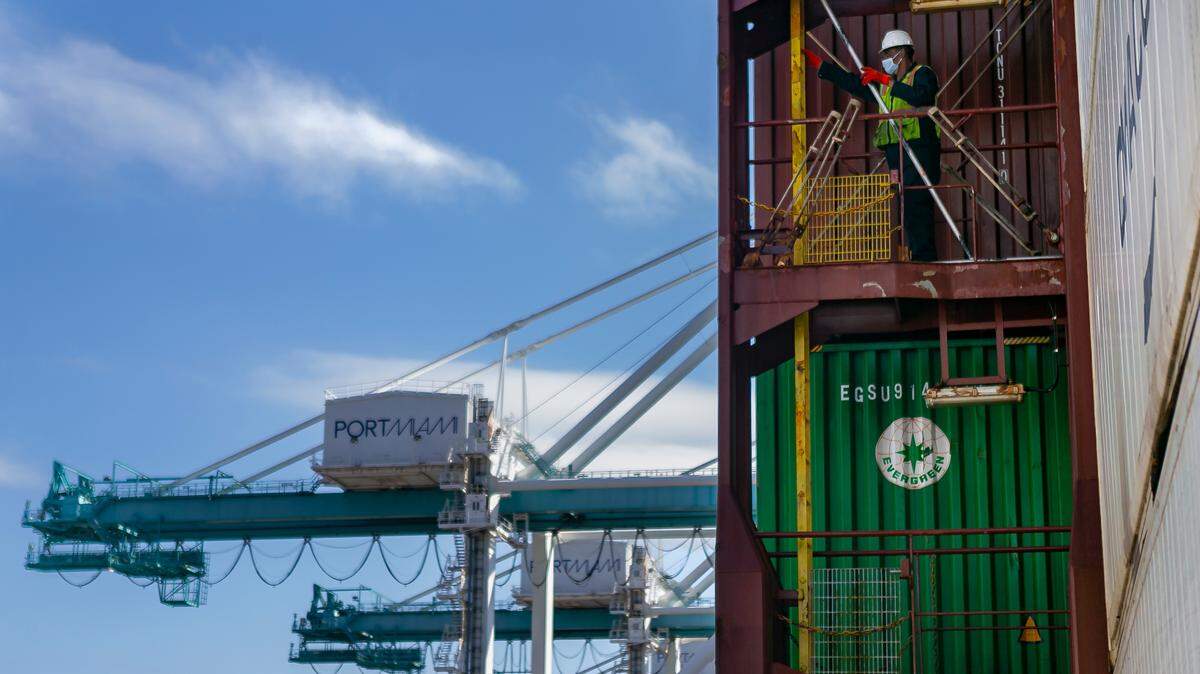 A longshoreman works to unhook containers inside a docked cargo ship at PortMiami on Saturday, February 20, 2021.