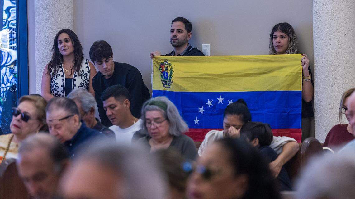 Members of the Maronite Young Adults Miami held a Venezuelan flag during a Holy Mass for Venezuela at Our Lady of Lebanon Catholic Church, focused on prayers for prosperity, peace, and freedom, a day after the United States attacked Venezuela and captured leader Nicolás Maduro and his wife, Cilia Flores, on January 04, 2026.