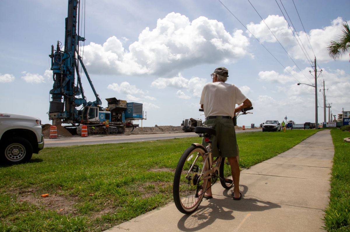 A man watches a buried seawall being built along State Road A1A in Ormond-by-the-Sea on June 9, 2025.