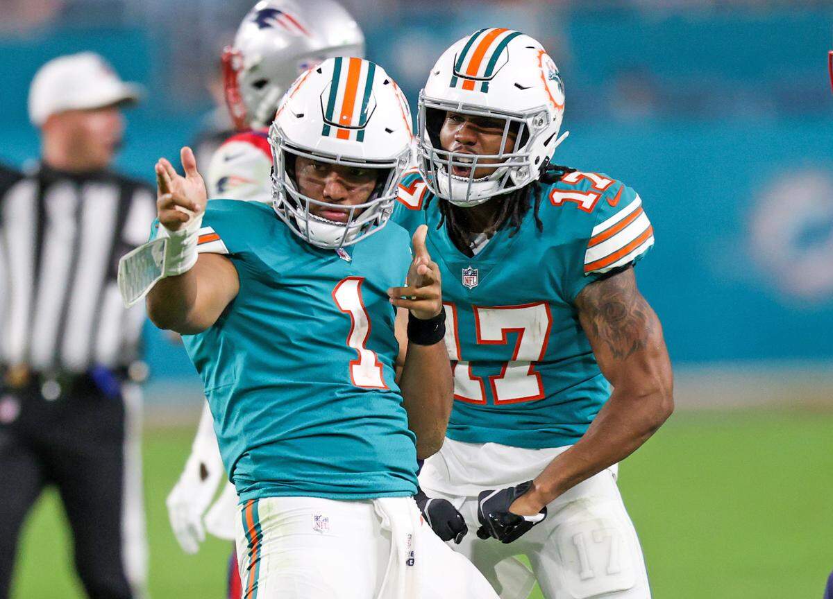 Miami Dolphins quarterback Tua Tagovailoa (1) celebrate with Dolphins wide receiver Jaylen Waddle (17) after running for a first down during the fourth quarter of an NFL football game against the New England Patriots at Hard Rock Stadium on Sunday, January 9, 2022 in Miami Gardens, Florida. (David Santiago Photo / Miami Herald)
