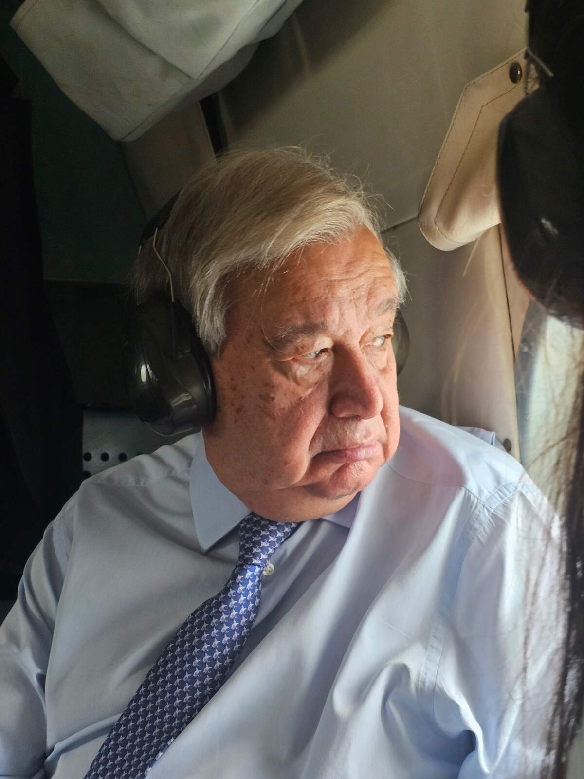 United Nations Secretary-General António Guterres looking out of a helicopter window as the crew flies over Haiti on Tuesday, June 16, 2026. Among the areas he sees is the large swath of the West region where residents are trapped by gangs.