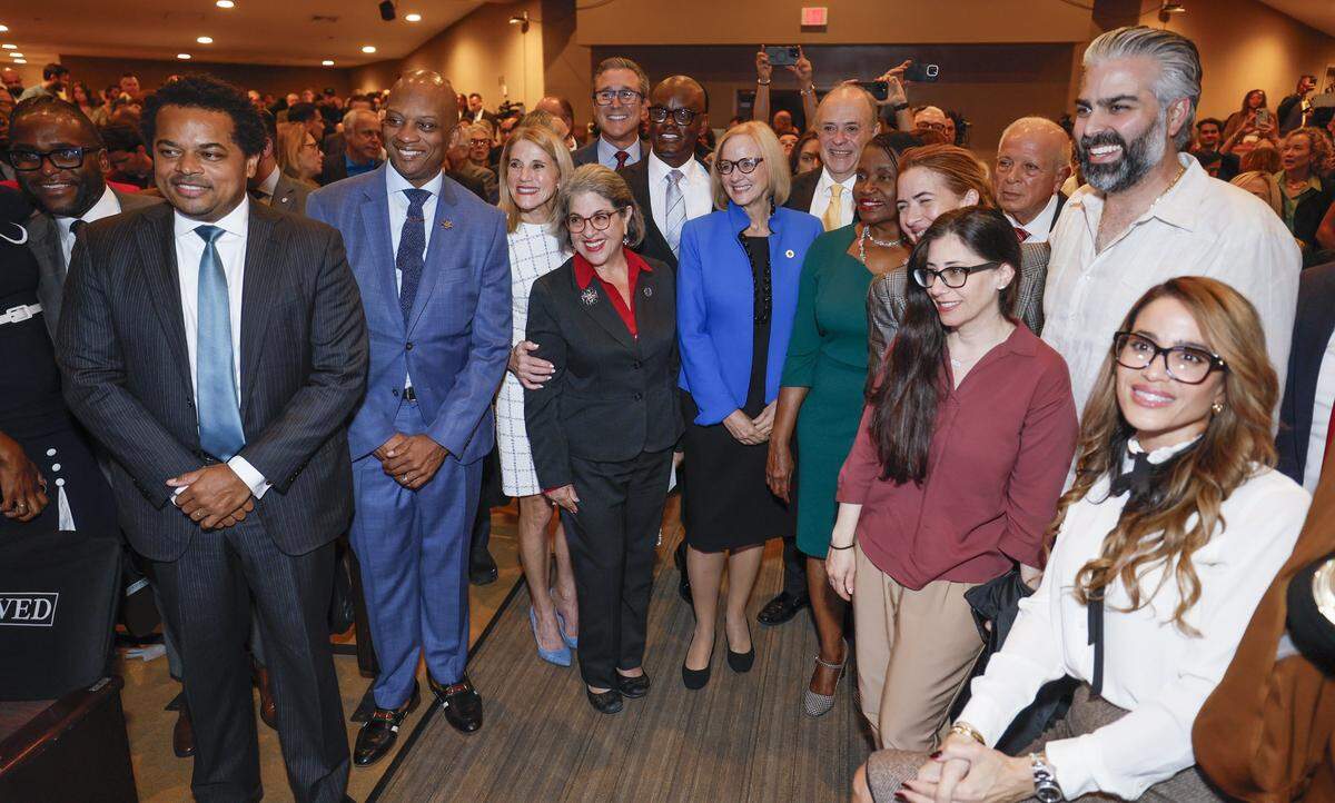 City of Miami Mayor Eileen Higgins, at center wearing blue, poses for photographs with Miami-Dade County Mayor Daniella Levine Cava and county commissioners after the installation ceremony for Higgins as the Mayor of the City of Miami at the Miami Dade College Wolfson Campus Auditorium in Miami, Florida, on Thursday, December 18, 2025. 