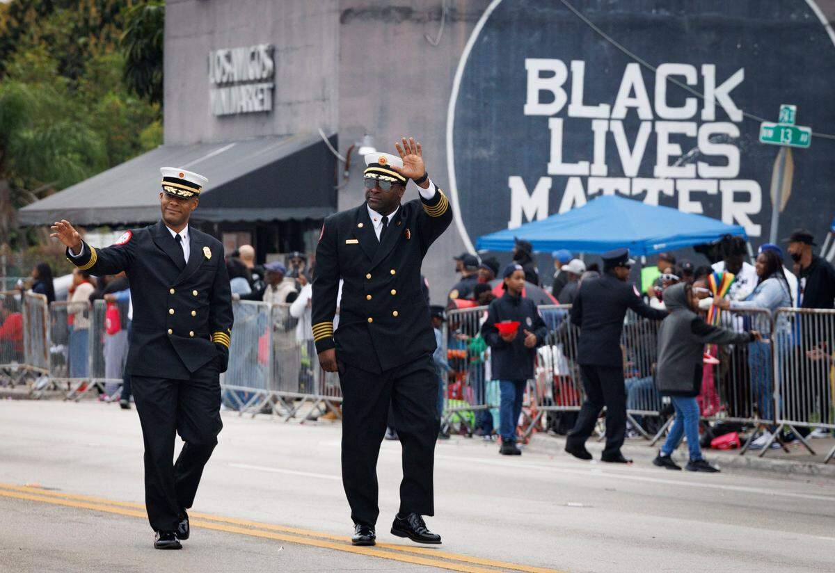 Two officers from the Professional Black Firefighters Association wave to the crowd during the Dr. Martin Luther King Jr. Day parade on Monday, Jan. 20, 2025, in Liberty City in Miami, Fla.