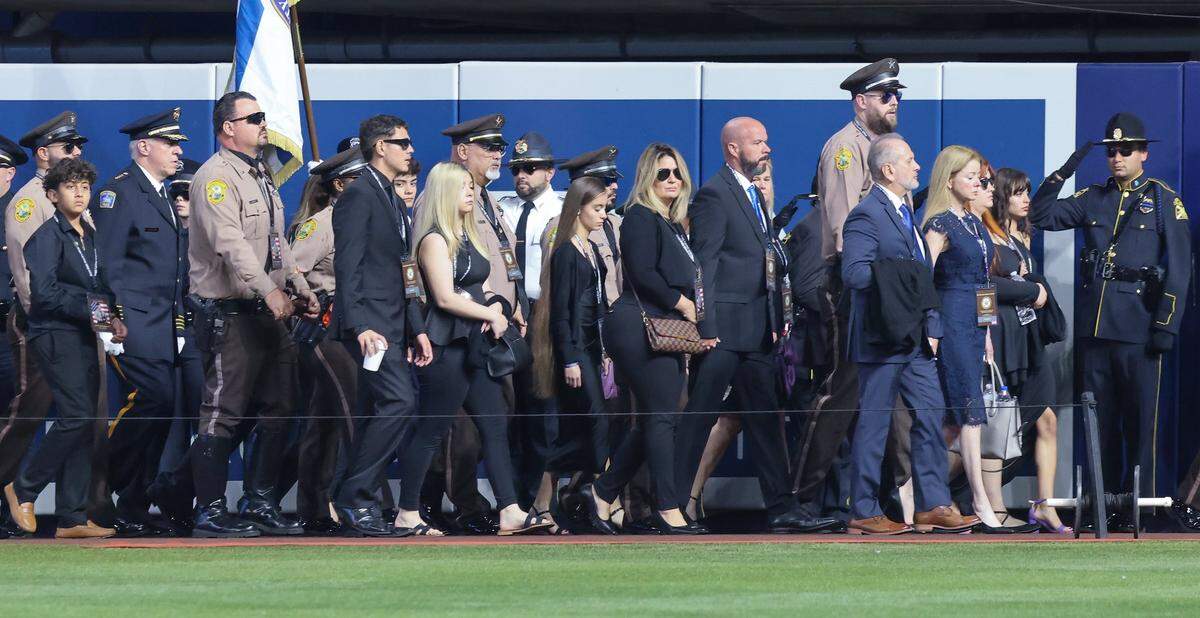 Devin Jaramillo’s parents, siblings and other family members walk behind the hearse during the funeral service for Miami-Dade Sheriff’s  Deputy Devin Jaramillo at loanDepot Park on Tuesday, Nov. 18, 2025, in Miami, Florida. 