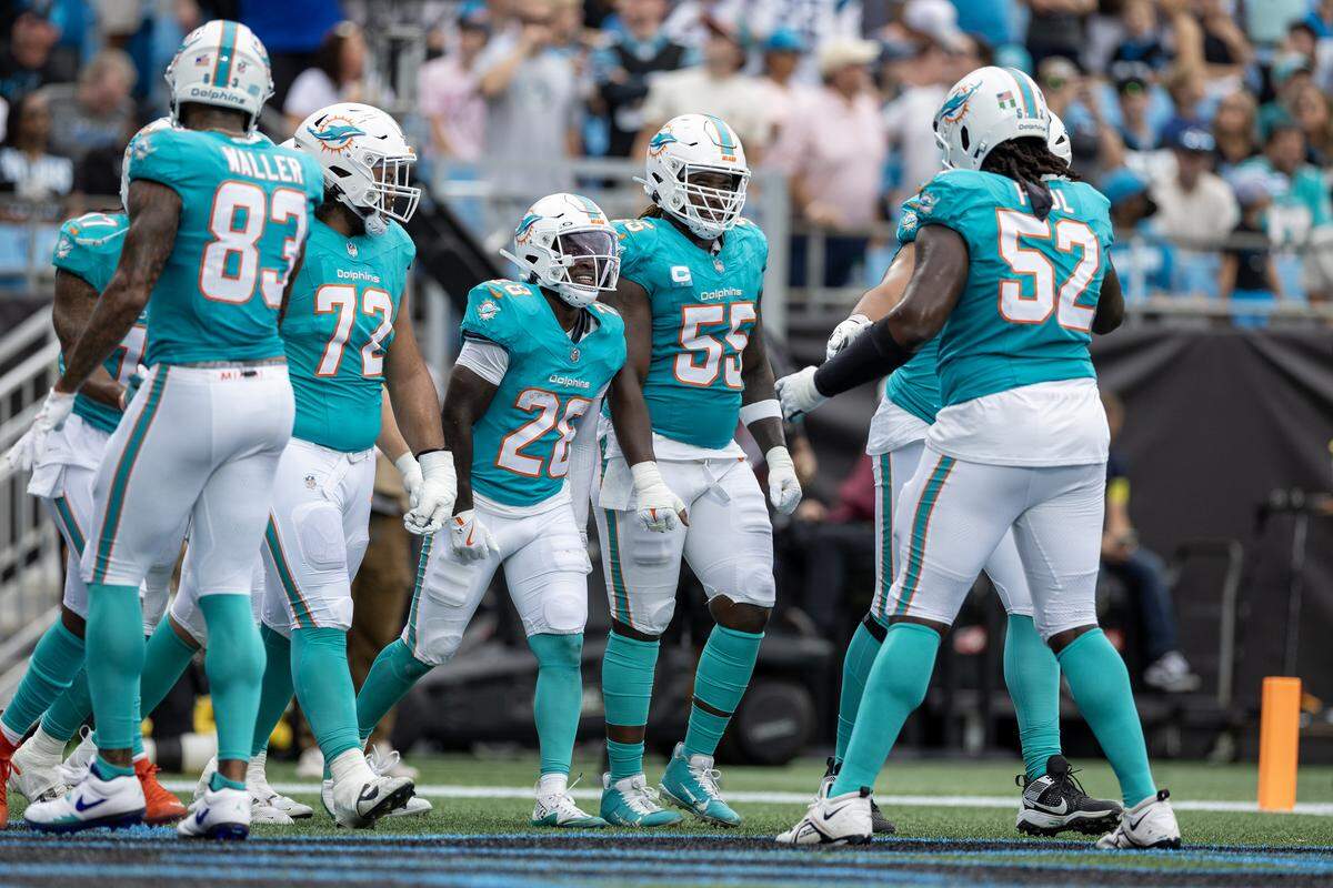 Miami Dolphins running back De’Von Achane (28) celebrates with teammates after scoring a touchdown during the first half of an NFL football game against the Carolina Panthers, Sunday, Oct. 5, 2025, in Charlotte, N.C.