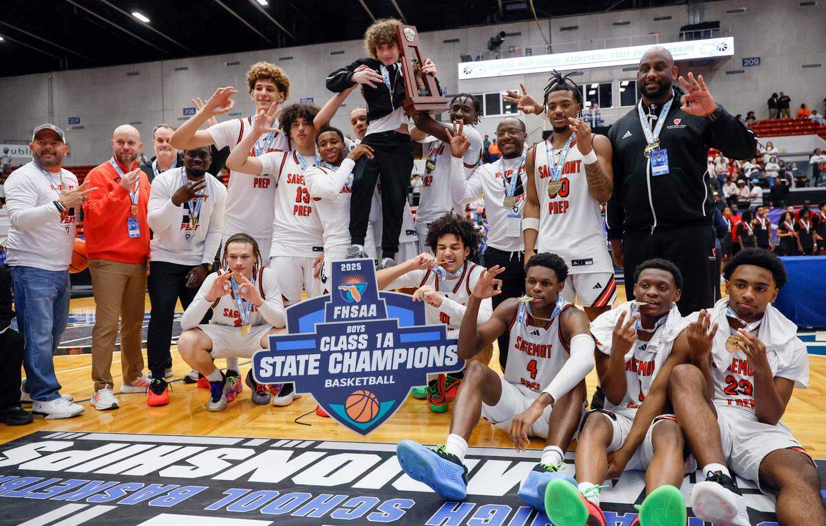 Sagemont teammates react as the State Championship Trophy is lifted in the air after defeating Victory Christian Academy in Boy’s Class 1A Basketball