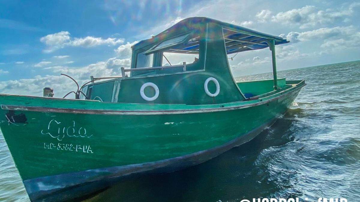 A green wooden boat is grounded in shallow water near Sombrero Beach in Marathon in the Florida Keys Saturday, April 10, 2021. Six people from Cuba arrived in the boat earlier that day.