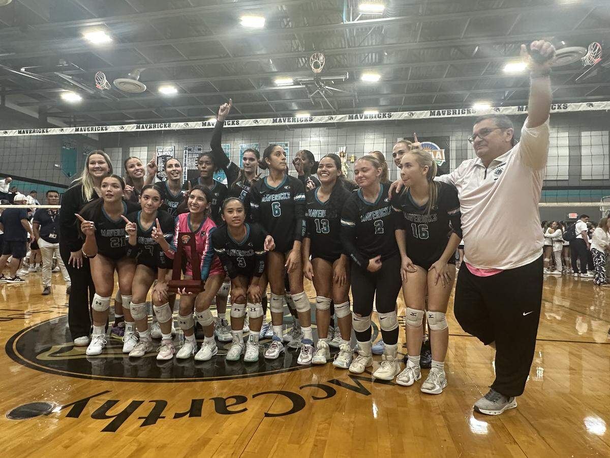Archbishop McCarthy girls’ volleyball coach Robert Perez (right) and the Mavericks’ players celebrate after beating Lourdes Academy on Wednesday night in the Region 4-5A championship match at Archbishop McCarthy High School in Southwest Ranches, Fla.