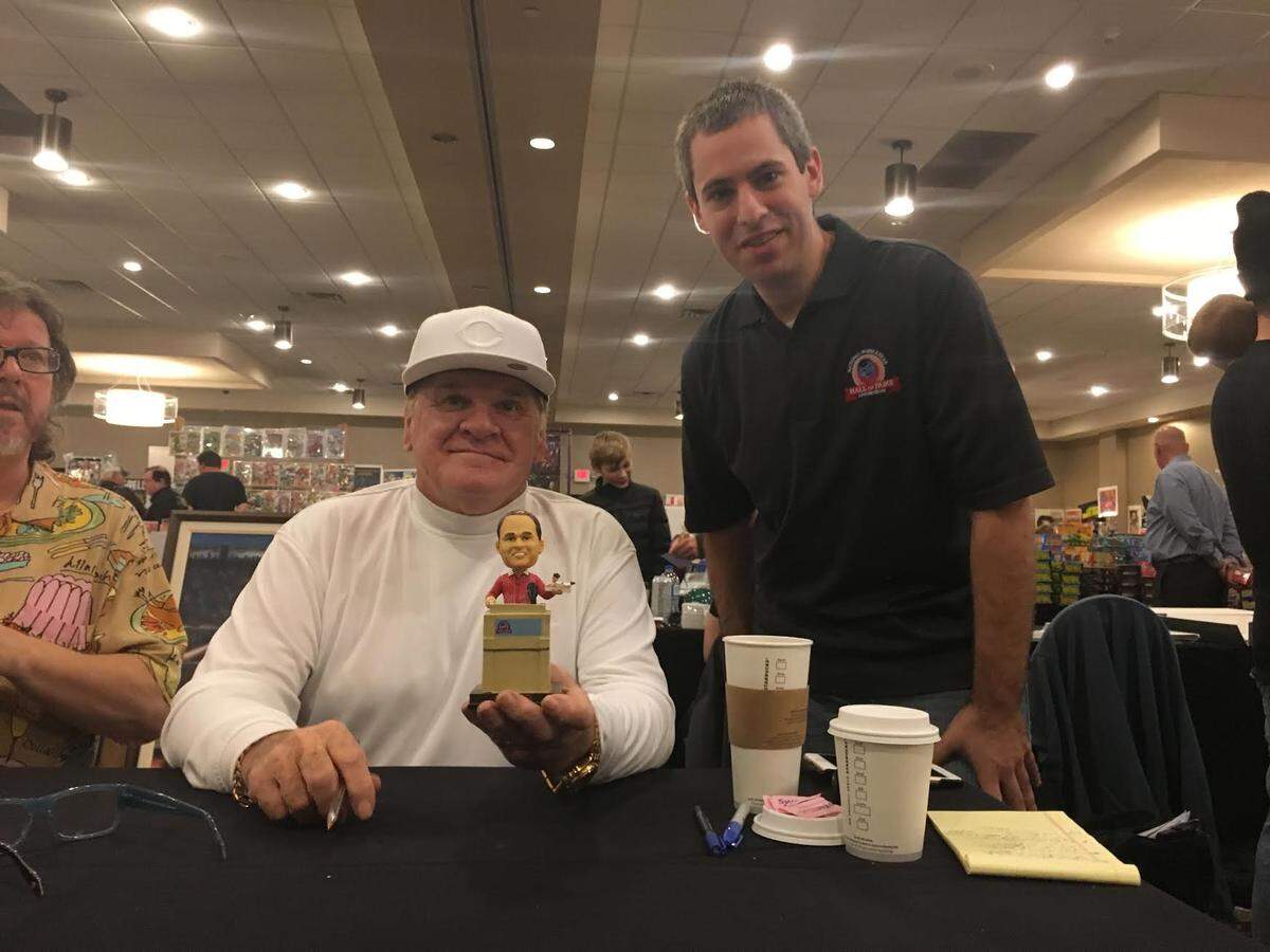 Pete Rose, holding his bobblehead, sits beside National Bobblehead Hall of Fame and Museum cofounder Phil Sklar. The recently opened Hall traces its inspiration to Miami’s Marlins Park.