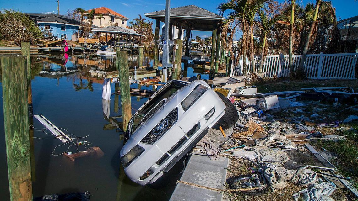 A 2003 Ford Mustang hangs off a seawall behind an Estero Boulevard house Wednesday, Oct. 26, 2022. The car was carried away in Hurricane Ian’s storm surge a month earlier.