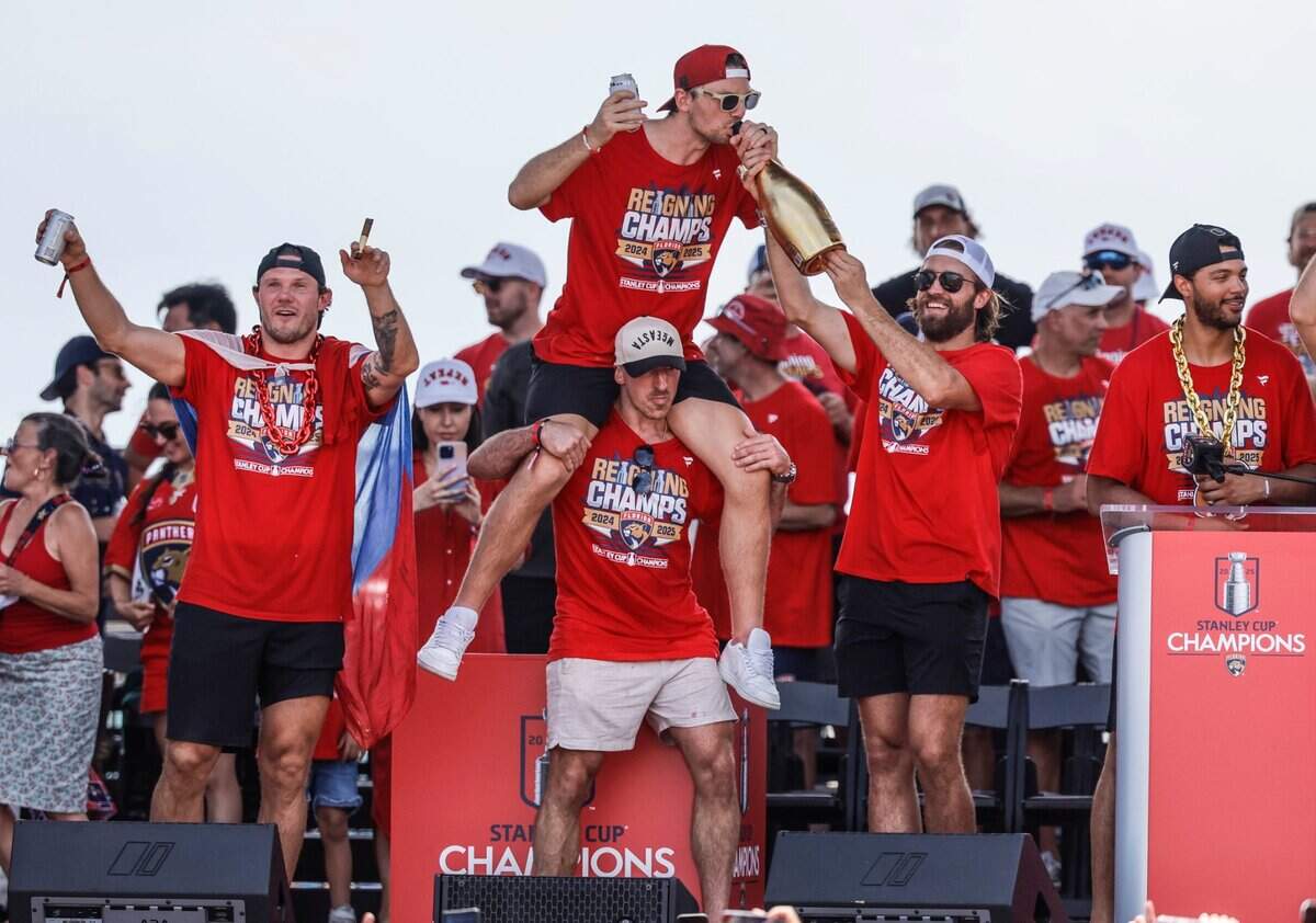 Florida Panthers defenseman Dmitry Kulikov, center Sam Reinhart riding on the shoulders of center Brad Marchand, and defenseman Aaron Ekblad celebrate on stage during the Stanley Cup victory parade and rally along A1A in Fort Lauderdale, Florida, on Sunday, June 22, 2025.