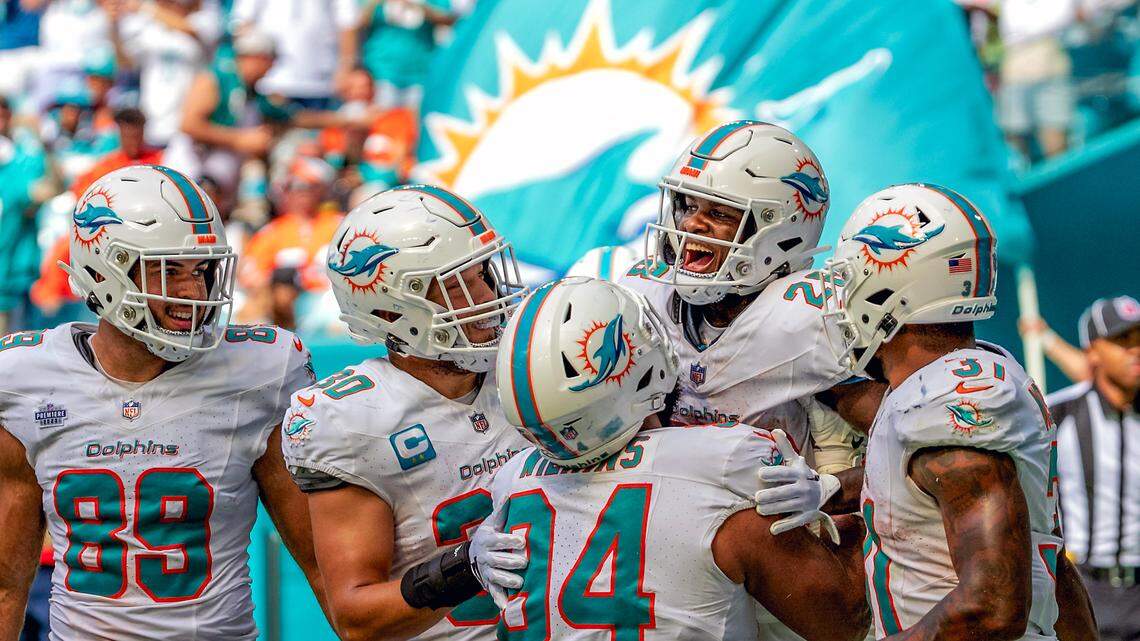 Miami Dolphins running back De’Von Achane (28) celebrates with teammates Julian Hill (89) Alec Ingold (30) Christian Wilkins (94) and Raheem Mostert (31) after scoring a touchdown against the Denver Broncos during fourth quarter of an NFL football game at Hard Rock Stadium on Sunday, Sept. 24, 2023 in Miami Gardens, Fl.