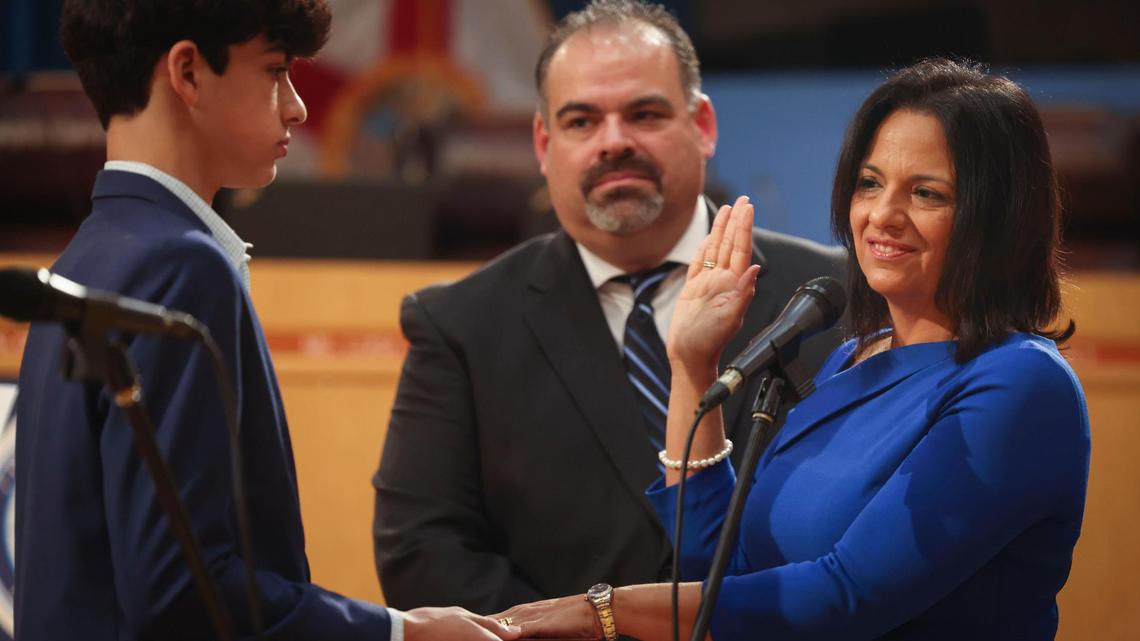 Maria Bosque-Blanco, whom Gov. DeSantis appointed to the Miami-Dade School Board on Tuesday night, is sworn in with her son, Richie, left, and her husband, Richard Blanco Jr., on Wednesday, Jan. 18, 2023, in downtown Miami.