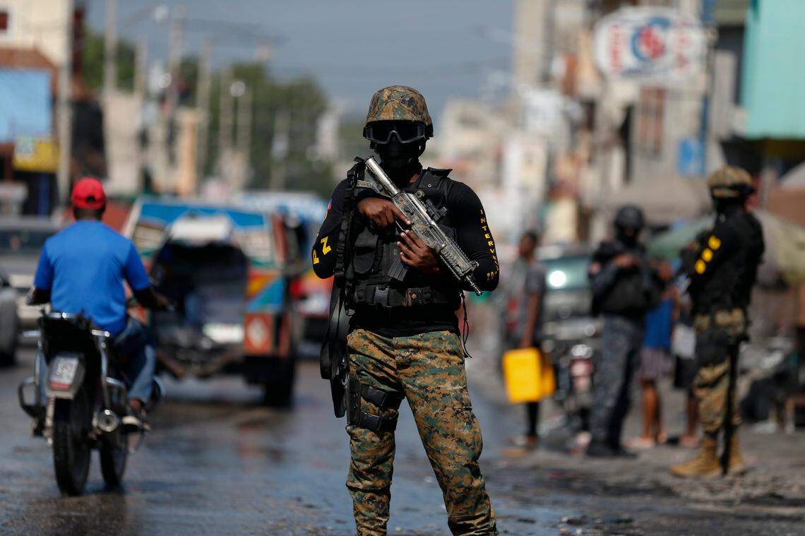 Members of the presidential guard provide security on the road as they await the passage of the president’s convoy on its way to the National Palace, in Port-au-Prince, Haiti, Tuesday, Oct. 15, 2019.