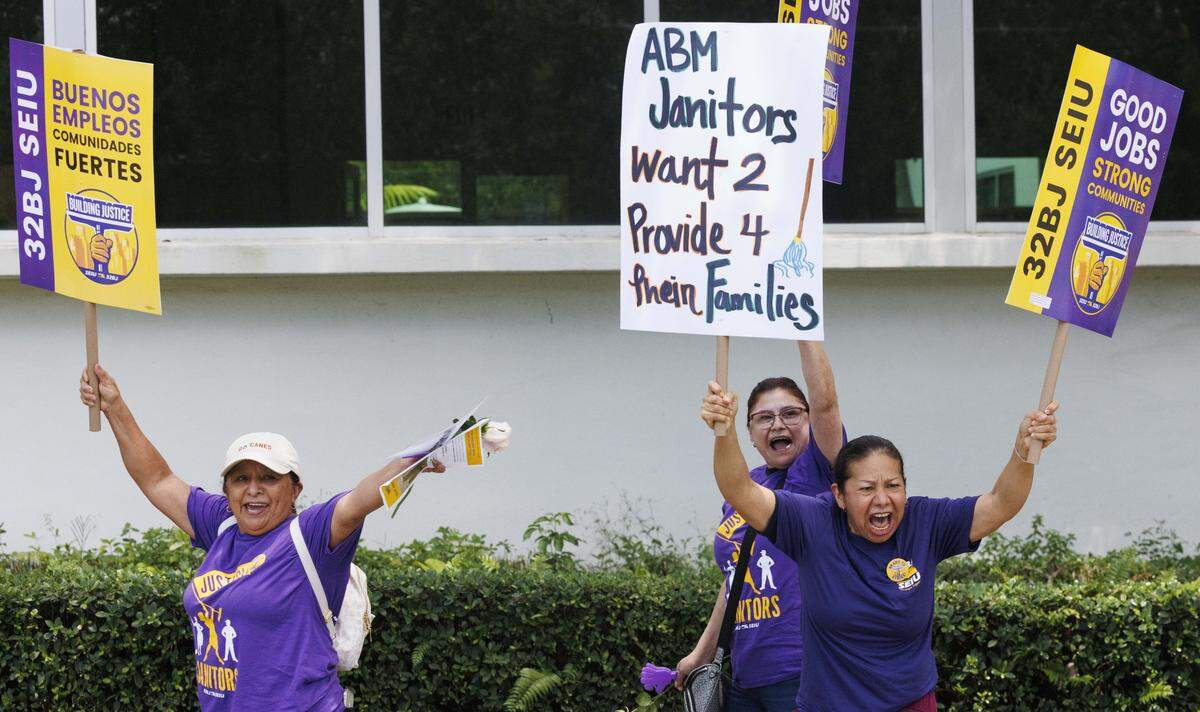 People chant at cars driving by during a strike vote march held by janitors employed by UM's cleaning contractor, ABM, on Monday, Aug. 18, 2025, outside of the University of Miami in Coral Gables, Fla.