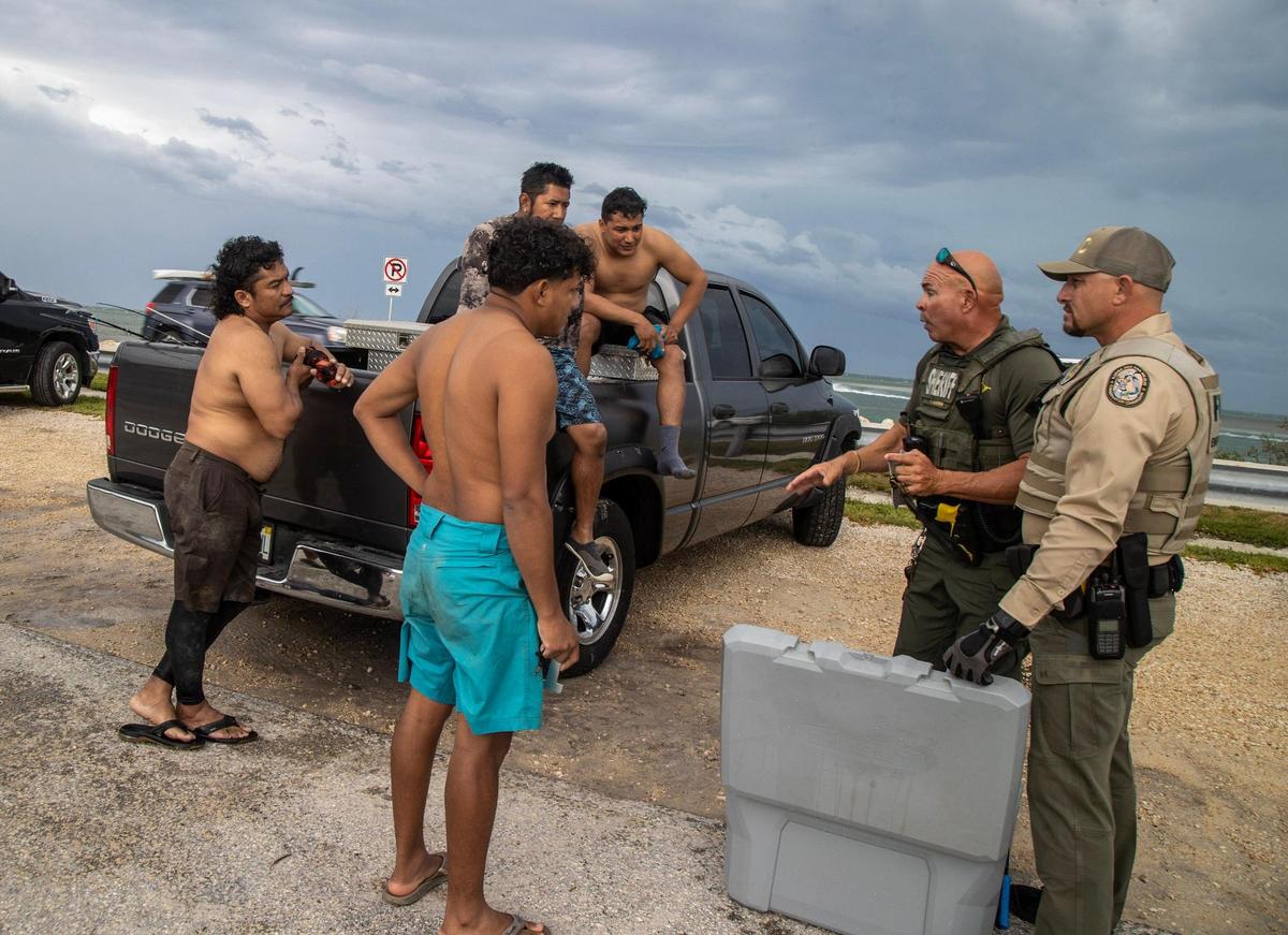 Monroe County Sheriff’s Office Marine Deputy Willie Guerra, center, and FWC officer Michael Goodwin get ready to check several Florida spiny lobsters captured by a group of men from Jupiter during the first day of lobster miniseason in the Florida Keys. on Wednesday, July 26, 2023.