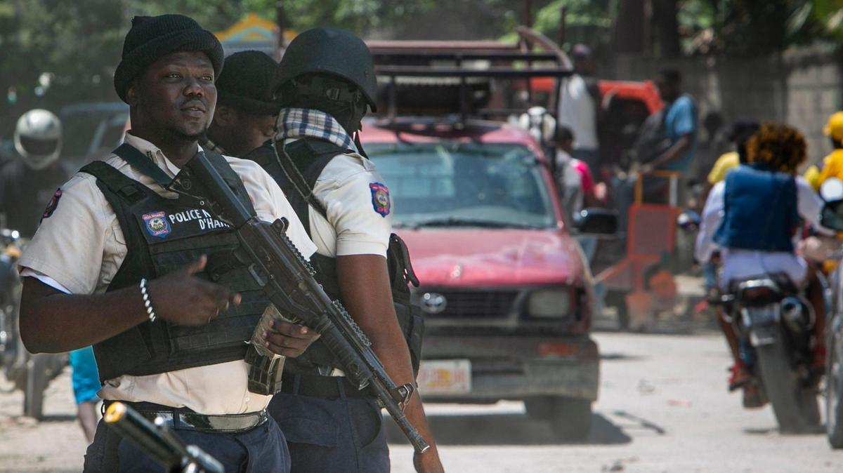 A Haitian National Police officer looks out over traffic at a police checkpoint on the outskirts of metropolitan Port-au-Prince on June 23, 2022. Following a deadly gang war, the streets of the capital have been tense and police presence beefed up.