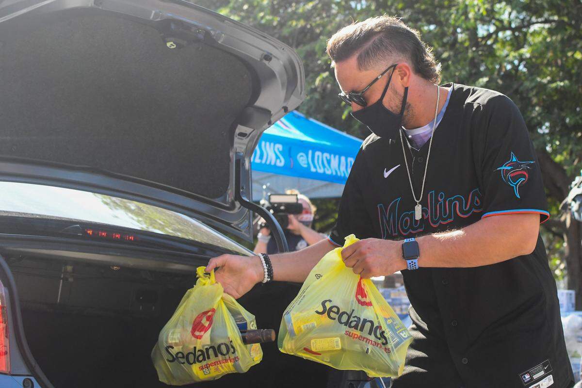 Miami Marlins shortstop Miguel Rojas hands out food at a drive-thru distribution at Marlins Park on Dec. 16, 2020.