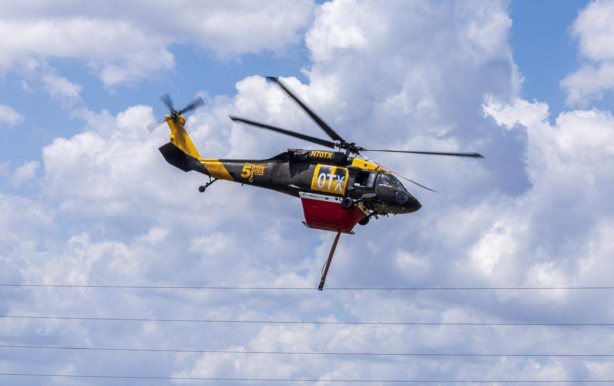 A water-tanker helicopter heads out to the south side of Tamiami Trail (U.S. 41) in the Everglades on Tuesday, April 28, 2026, to drop its load on flames burning thousands of acres of brush.