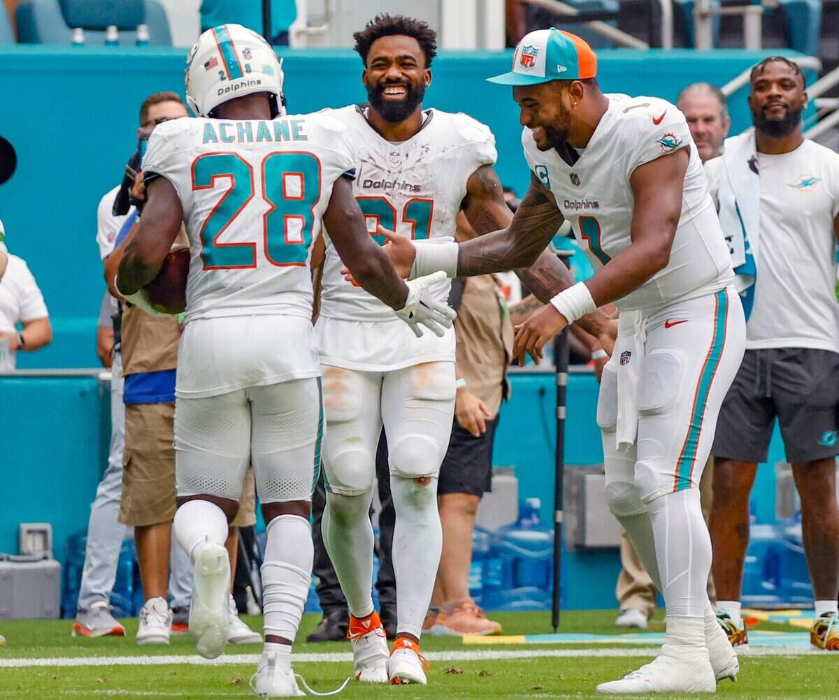 Miami Dolphins running back De’Von Achane (28) celebrates his touchdown with running back Raheem Mostert (31) and quarterback Tua Tagovailoa (1) in the fourth quarter against the Denver Broncos at Hard Rock Stadium in Miami Gardens on Sunday, September 24, 2023.
