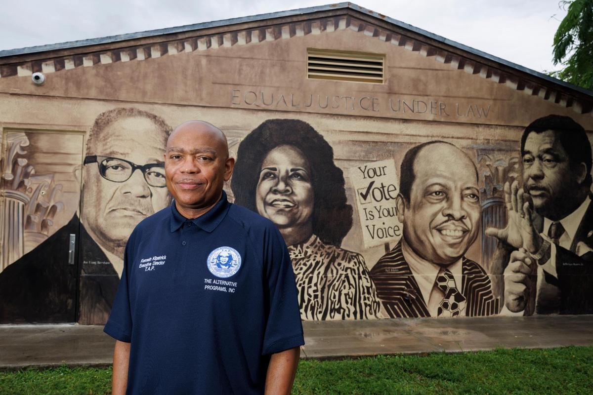 Kenneth Kilpatrick, president of the Brownsville Civic Neighborhood Association, poses with a mural of neighborhood historical figures on Wednesday, July 23, 2025, in the Brownsville neighborhood of Miami. Kilpatrick thinks there more pros than cons to becoming a city. “There’s enough dormant space to bring in [needed resources] … and make sure our money doesn’t leave the city,” said Kilpatrick.