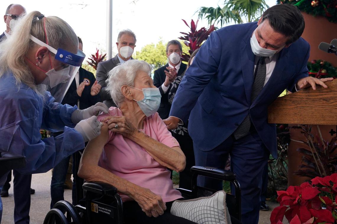 Florida Gov. Ron DeSantis asks Vera Leip, 88, how she feels after nurse Christine Philips, left, administered the Pfizer vaccine at John Knox Village, Wednesday, Dec. 16, 2020, in Pompano Beach, Florida. DeSantis prioritized nursing home residents and healthcare workers to receive the vaccine.