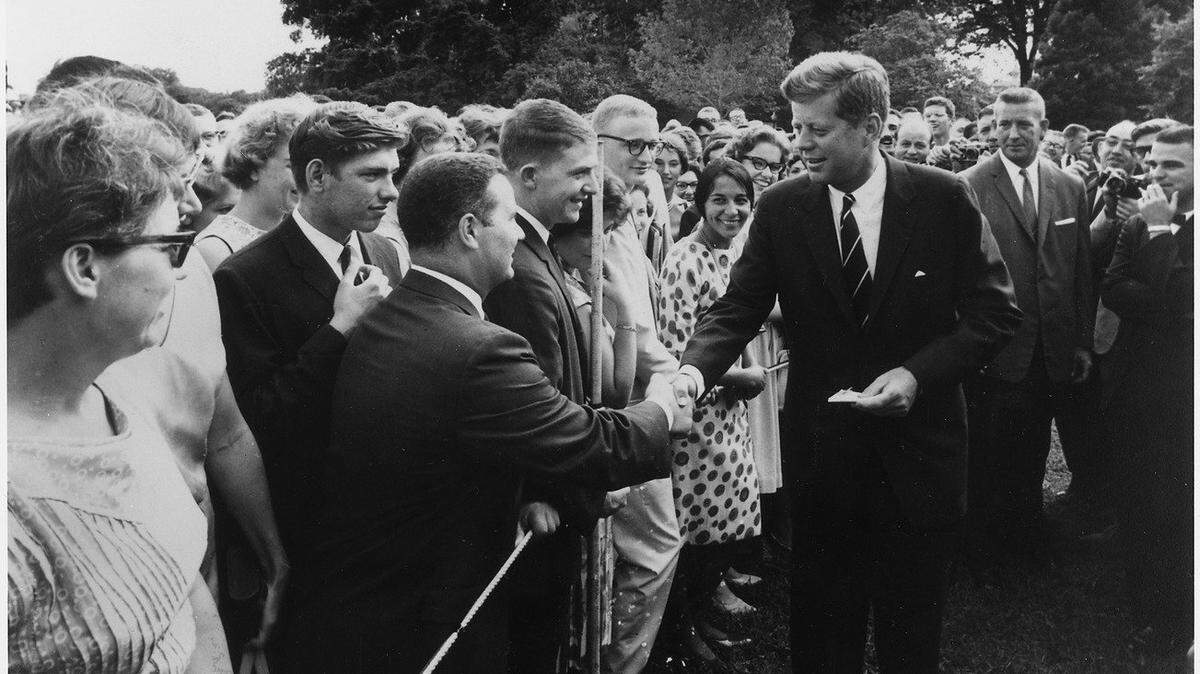 President John F. Kennedy greets Peace Corps volunteers on the South Lawn of the White House in 1962. Kennedy created the agency through an executive order the previous year.