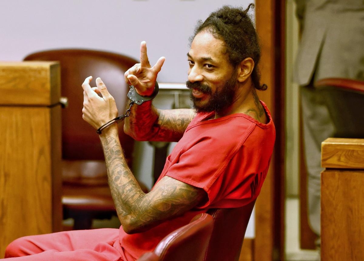 Steven Gallon IV, hijo del miembro de la Junta Escolar de Miami Dade Steve Gallon y acusado de dispararle a un policía encubierto de Miami-Dade, haciendo señas a amigos y familiares durante una audiencia judicial en la que se le denegó la fianza el jueves.