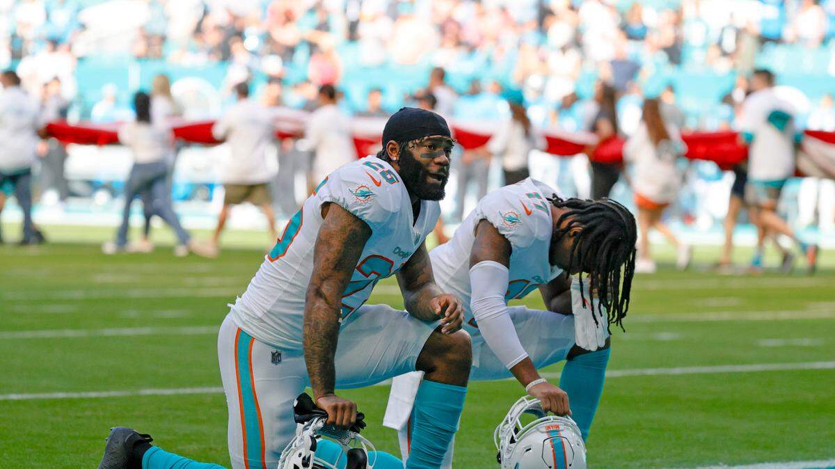 Miami Dolphins players Xavien Howard (25) and Jaylen Waddle (17) kneeling before of an NFL football game against the Carolina Panthersat Hard Rock Stadium on Sunday, November 28, 2021 in Miami Gardens, Florida.