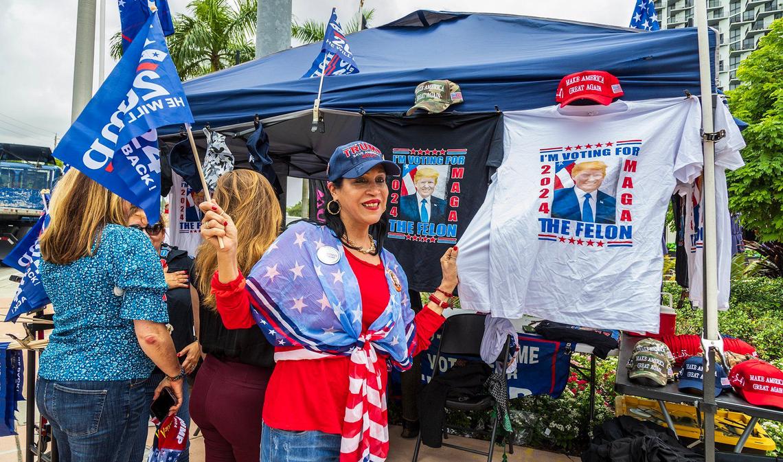 Former President Donald Trump supporter Maribel Gonzalez of Miami posed with some Trump t-shirts as she arrived early morning for a late night rally at the Trump National Doral Miami, in Doral on Tuesday, July 09, 2024.