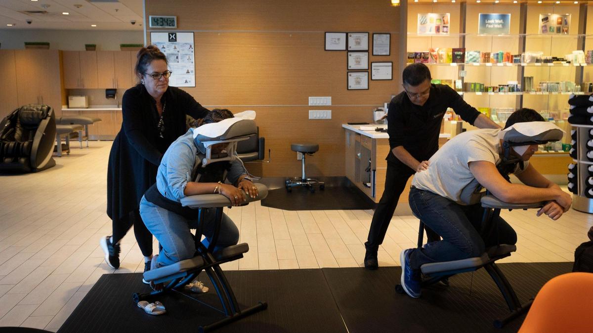 Tania Oropesa, left, massage therapist, and her co-worker massage travelers who came into the XpresSpa by gate D-10 for a massage on Monday, Jan. 29, 2024, at Miami International Airport. “Massage and our massage therapy beds are good for circulation and stress on long trips,” said Assistant Spa Manager Erika O’Connor.