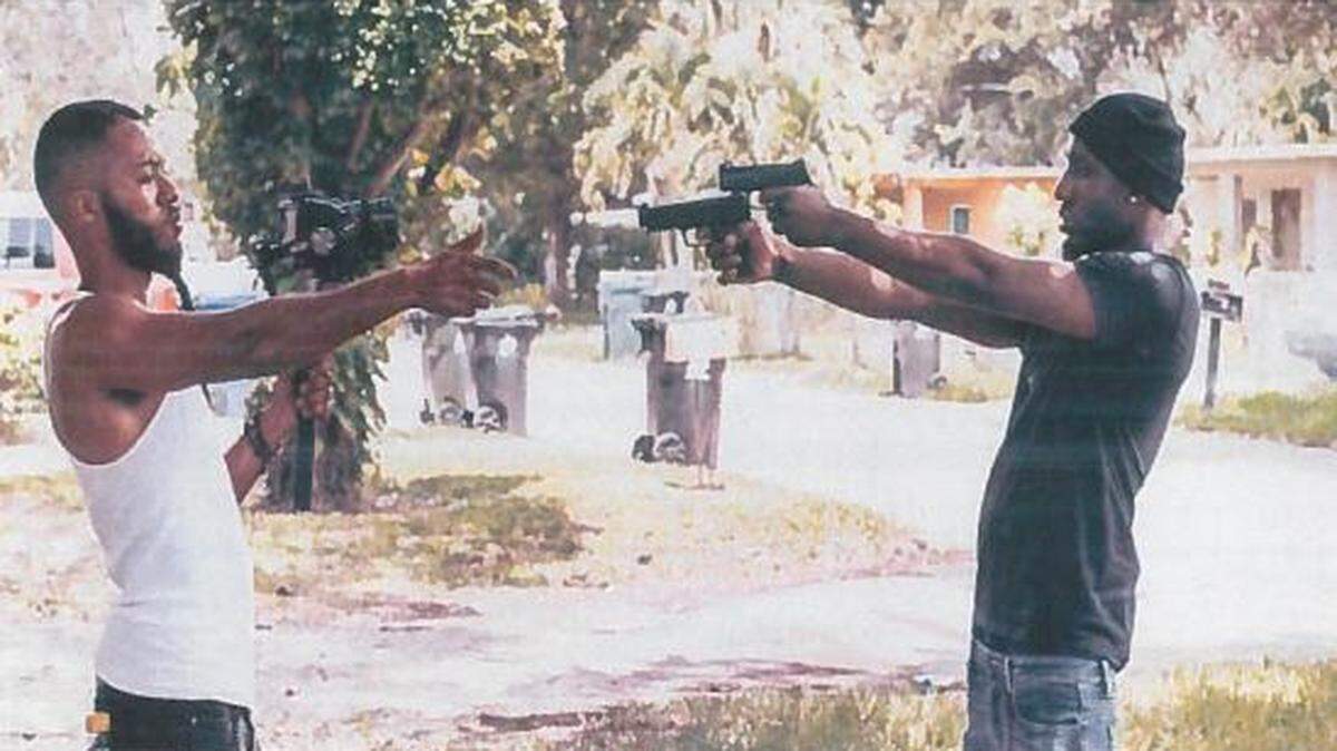 Fort Pierce rapper Lil Polo Da Don holding two FN handguns while filming a video in Broward. The picture was found by investigators in a Dropbox.