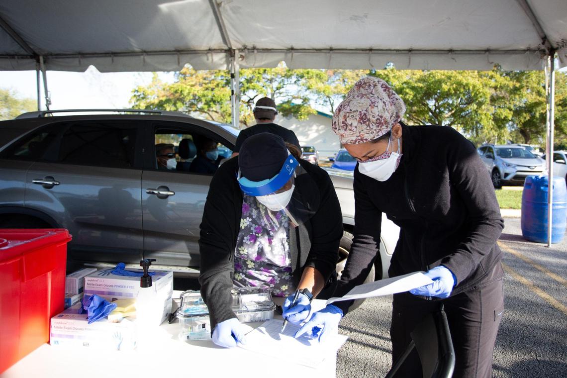 Healthcare workers prepare paperwork prior vaccination at the first walk-up mobile testing site open to Florida resident that won’t require appointments at Miami Carol City Park in Miami Gardens in Miami Gardens, Florida on Saturday, February 20, 2021.