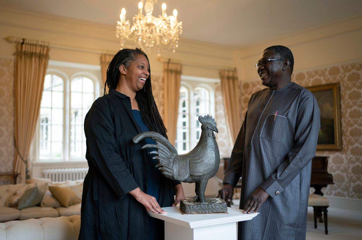 Master of Jesus College Sonita Alleyne, left and Director General of Nigeria’s National Commission for Museums and Monuments Professor Abba Isa Tijani pose for a photo ahead of a ceremony at Jesus College Cambridge, where the looted bronze cockerel, known as the Okukur, will be returned to Nigeria, in Cambridge, England, Wednesday, Oct. 27, 2021. Jesus College announced in 2019 that it would return the Okukor, a statue that was taken from the Court of Benin in what is now Nigeria by British colonial forces in 1897. (Joe Giddens/PA via AP)
