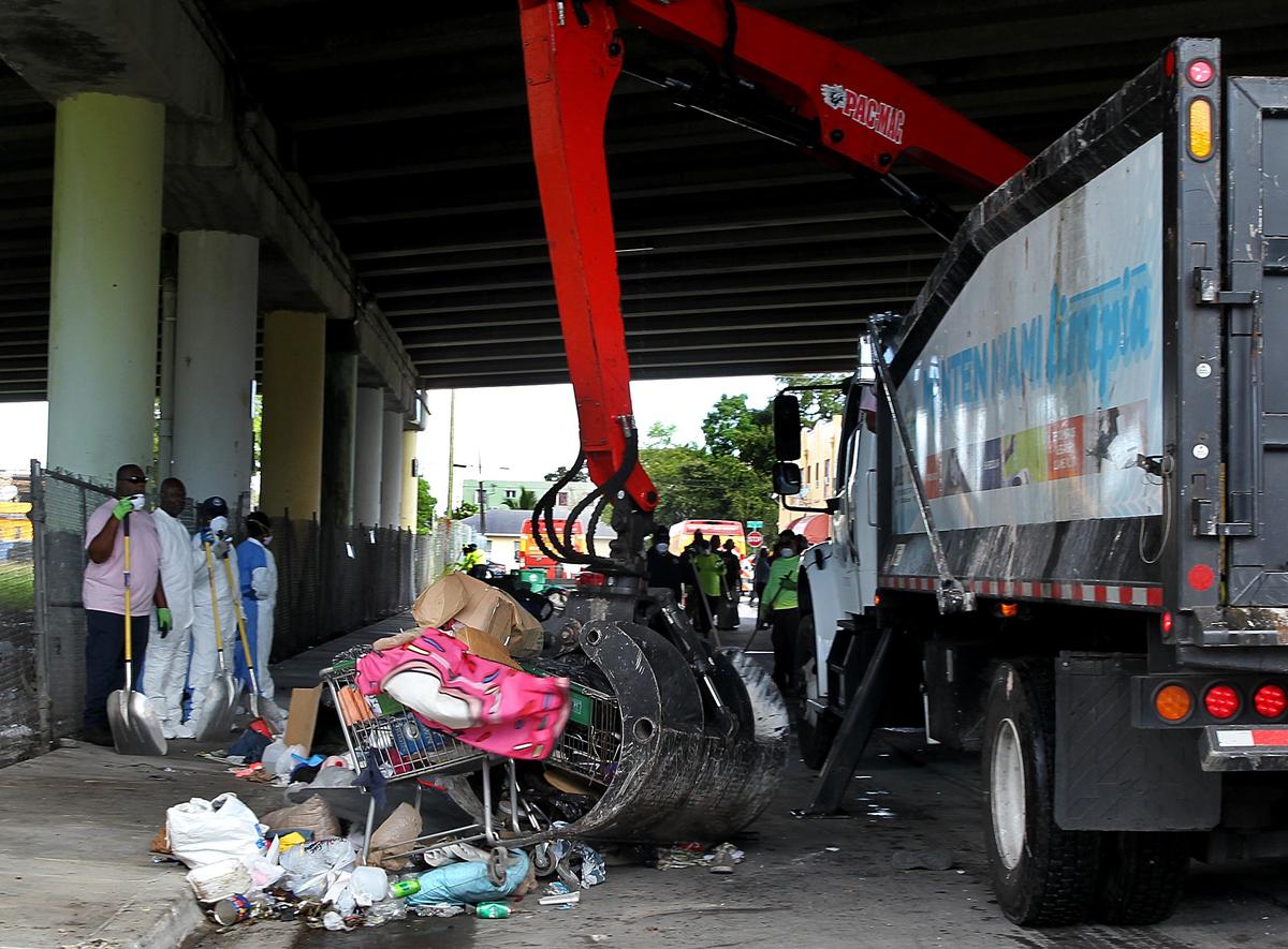 In a Friday morning cleanup of streets under the Dolphin Expressway in Overtown, Miami sanitation workers picked up trash and discarded items left by homeless people.